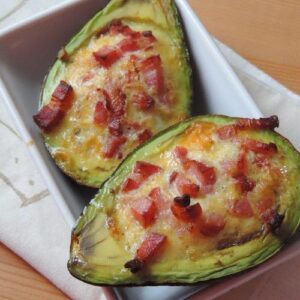 Gevulde avocado met ei en spekjes als warm glutenvrij ontbijt.