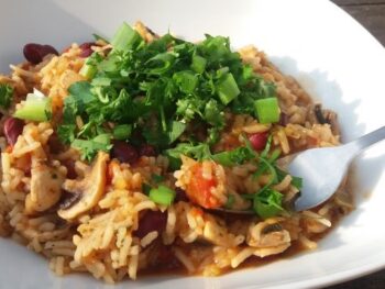 Vegetarische Jambalaya - eenpansgerecht met rijst - in een wit vierkant diep bord