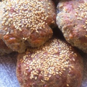 Zelfgemaakte glutenvrije broodjes van amandelmeel met sesamzaadjes erop.