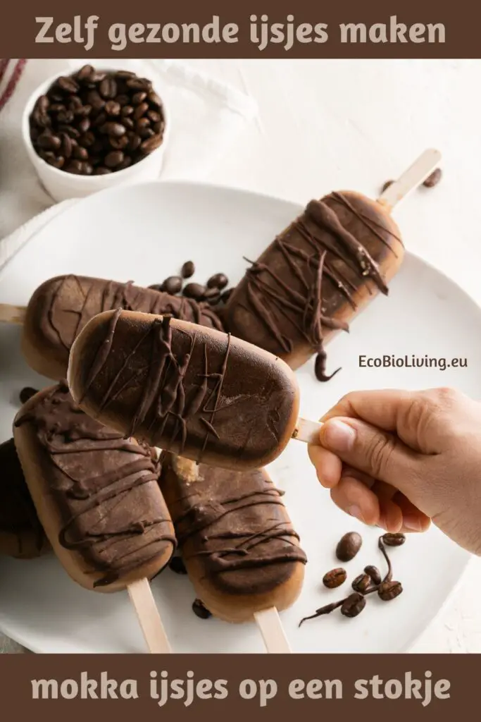 Zelfgemaakte mokka-ijsjes op stokjes met krokante chocolade decoratie - op een wit bord