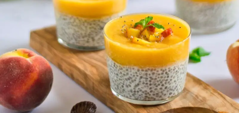 Chia pudding met perzik toplaag en stukjes perzik erop in glaasjes